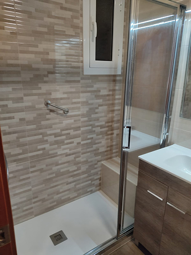 lavabo amb dutxa amb seient d'obra. Amb diferents tipus de rajoles a la zona d'aigües
